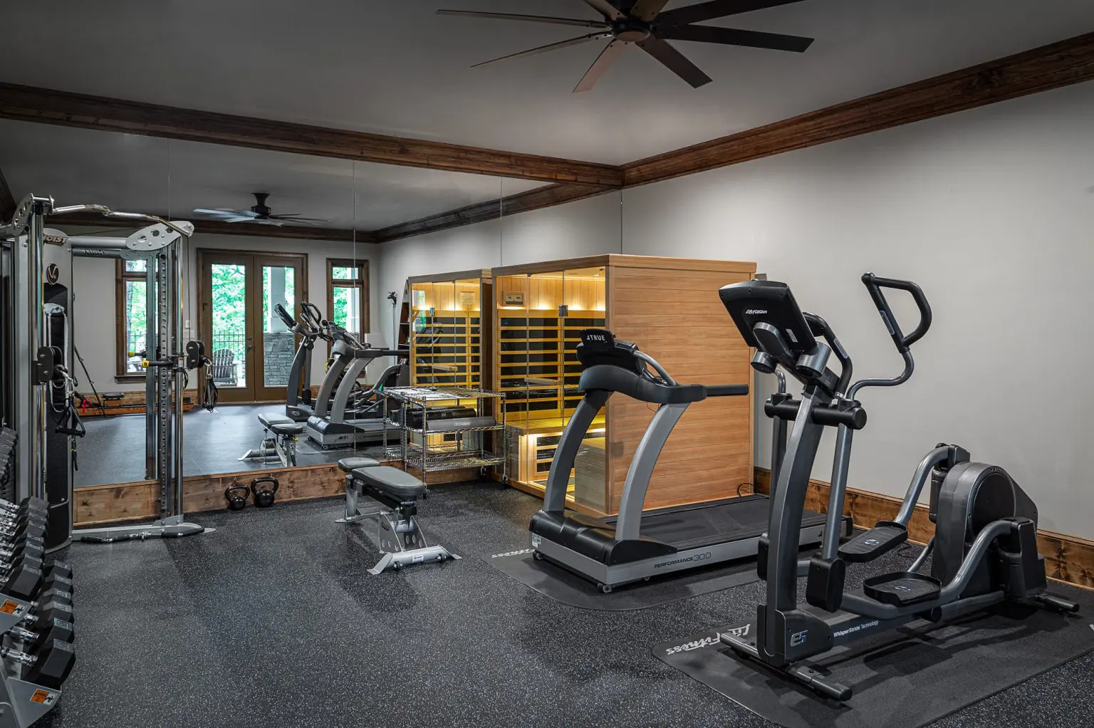 Home gym with modern fitness equipment and infrared sauna designed by Michael James Remodeling. Home gym with modern fitness equipment and infrared sauna designed by Michael James Remodeling.